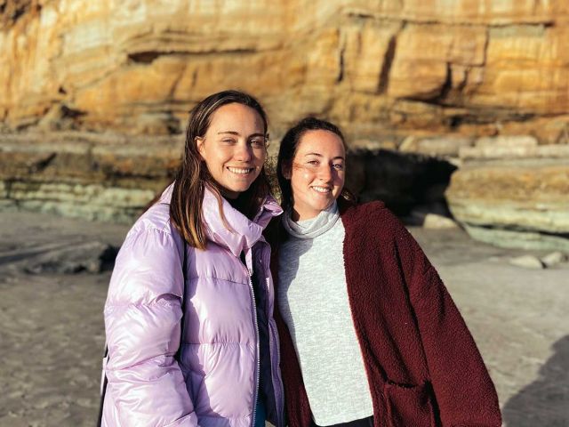 Isabel on a beach with a friend.